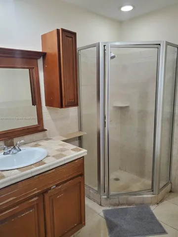 a bathroom with a shower sink and mirror