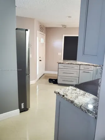 a kitchen with granite countertop a sink and stainless steel appliances