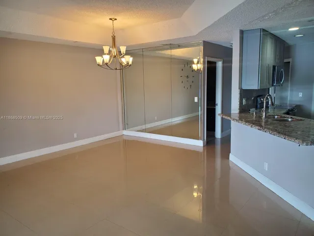 a view of a kitchen with a sink dishwasher a refrigerator and chandelier