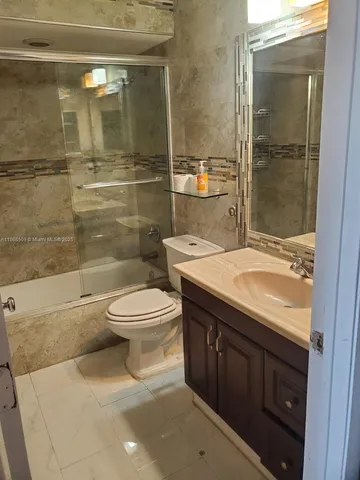 a bathroom with a granite countertop toilet a sink and shower