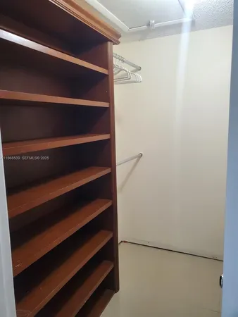 a view of walk in closet with empty racks
