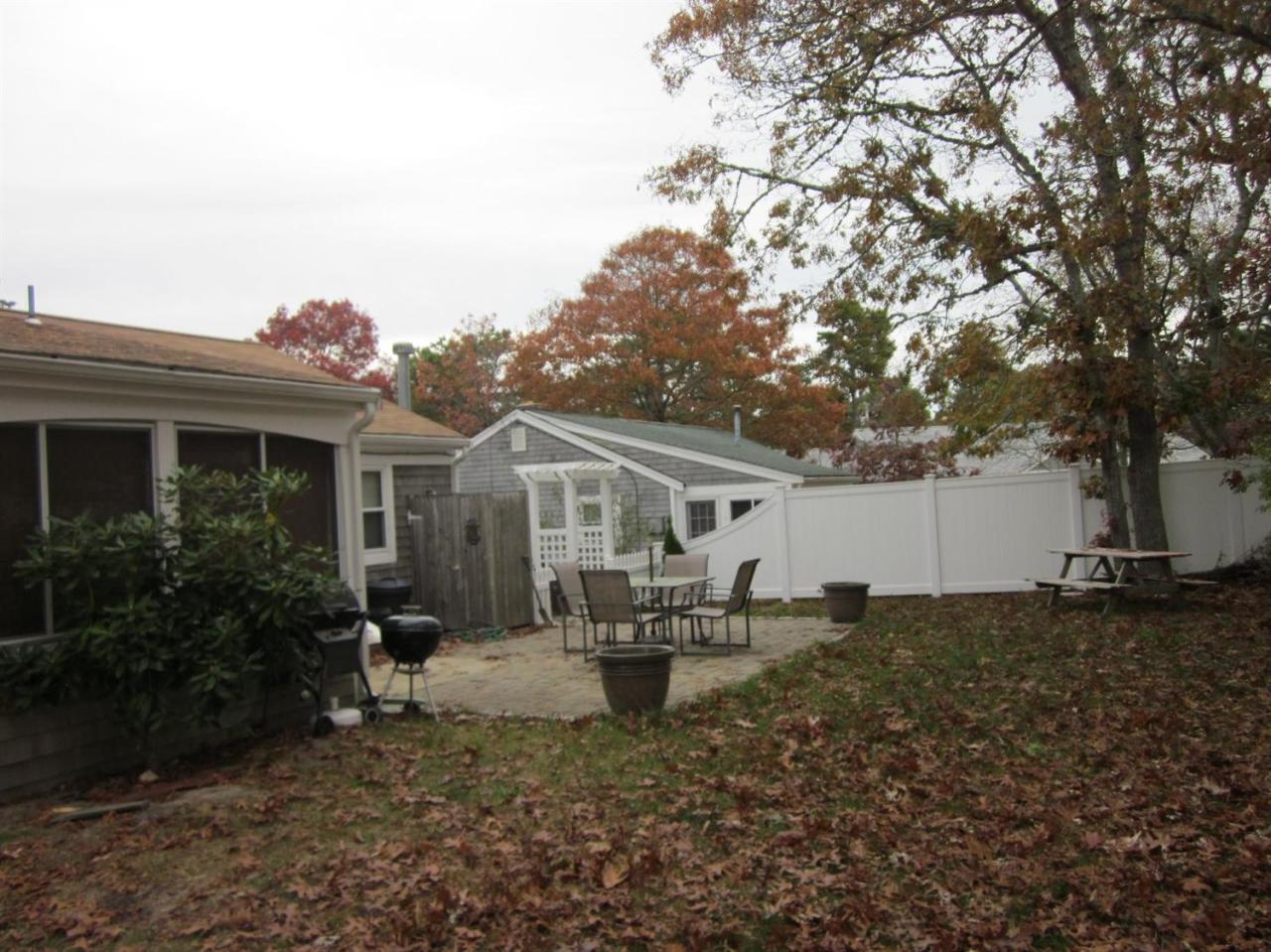 12 Captain Chase Road Dennis Port, MA 02639 - Photo 11 of 14 a view of a patio with table and chairs under an umbrella