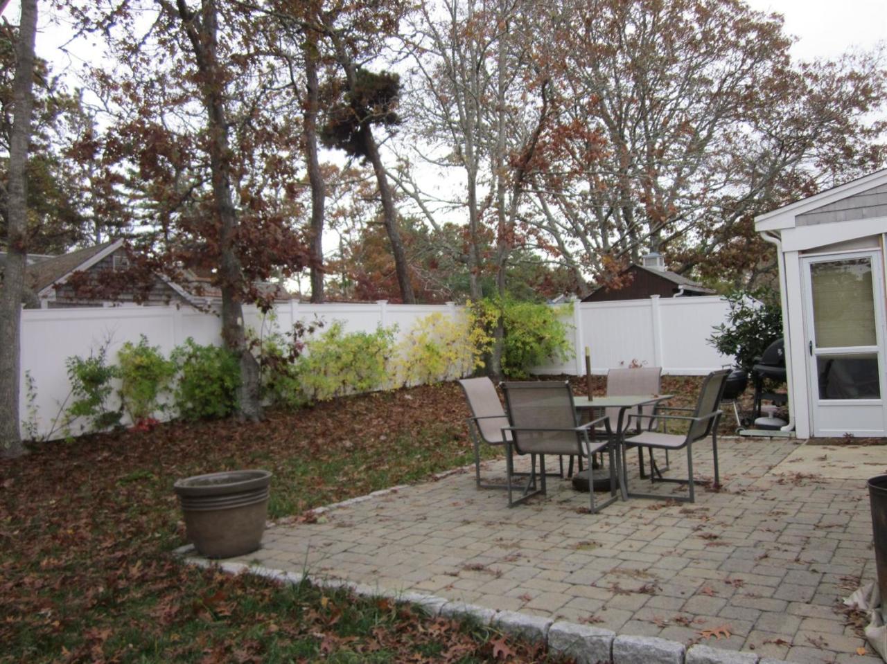 12 Captain Chase Road Dennis Port, MA 02639 - Photo 12 of 14 a view of a backyard with table and chairs potted plants and tree