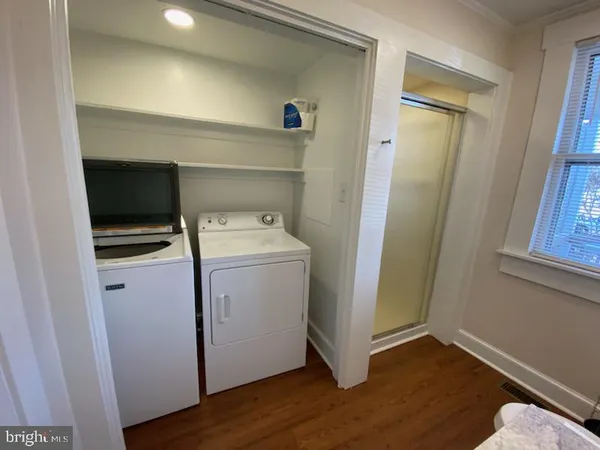 a utility room with wooden floor washer and dryer