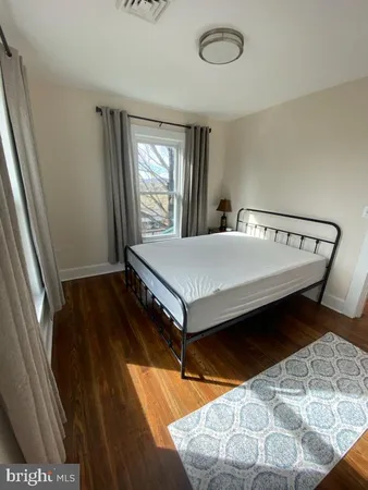 a bed sitting in a bedroom next to a window