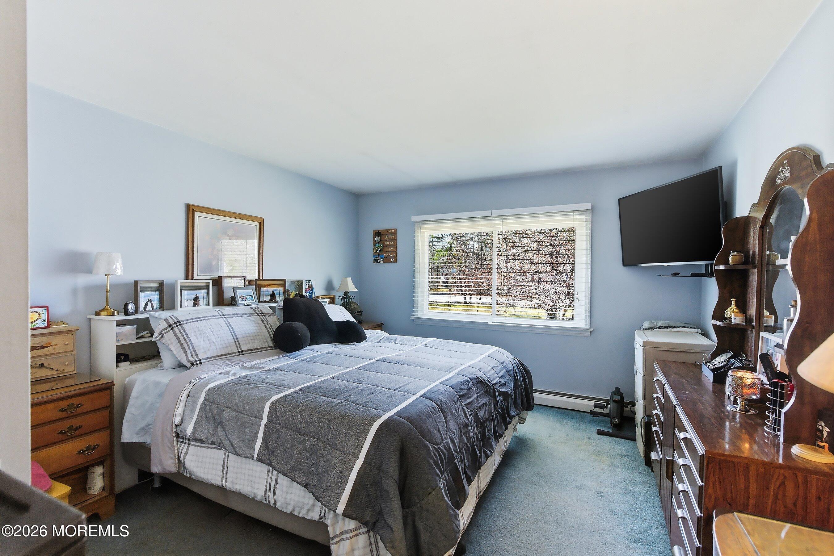 745 Oak Glen Road Howell, NJ 07731 - Photo 19 of 46 a bedroom with a bed a flat screen tv and a window