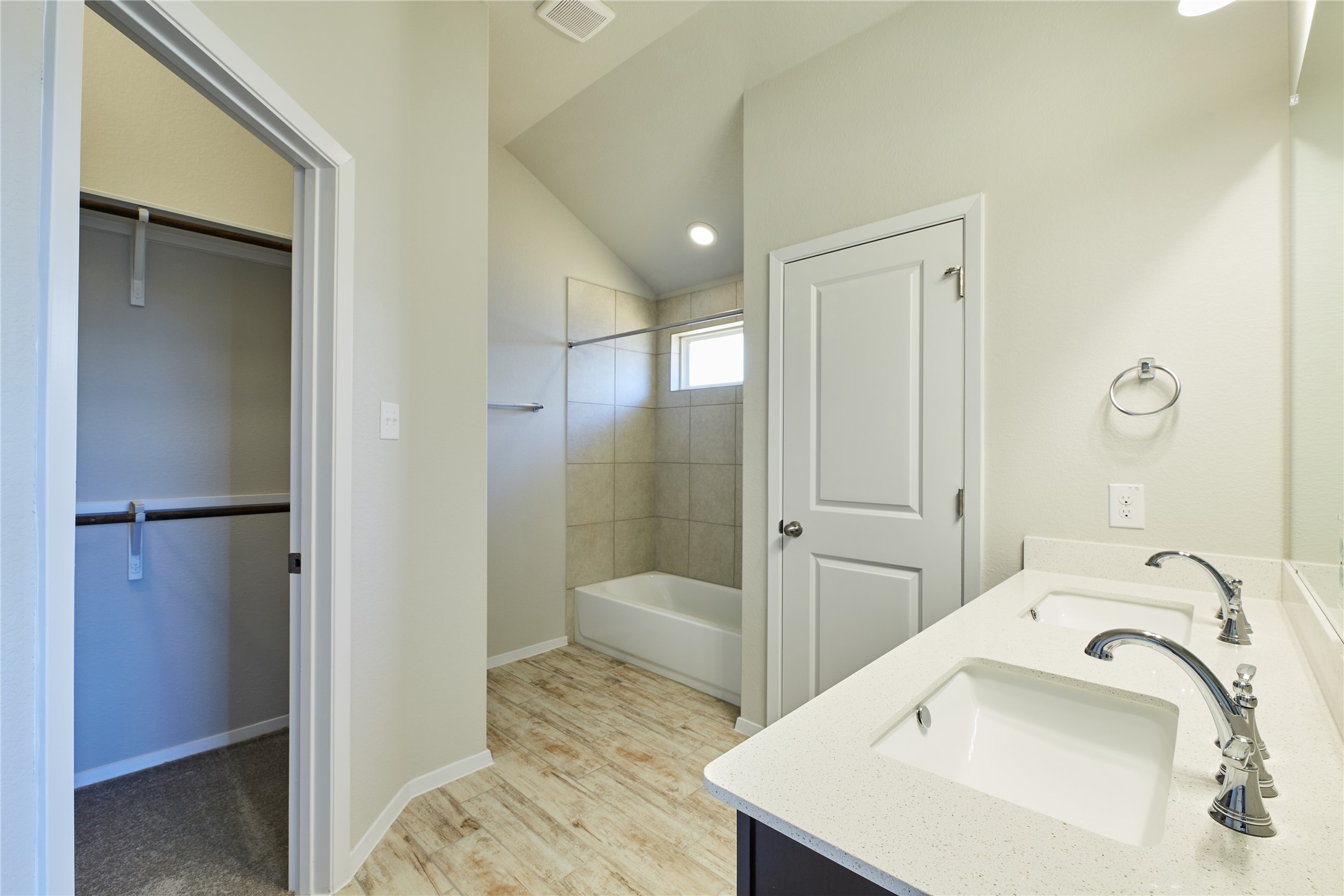 303 Trailside Lane Bastrop, TX 78602 - Photo 13 of 25 Full bathroom with a walk in closet, double vanity, light wood-type flooring, shower / washtub combination, and vaulted ceiling