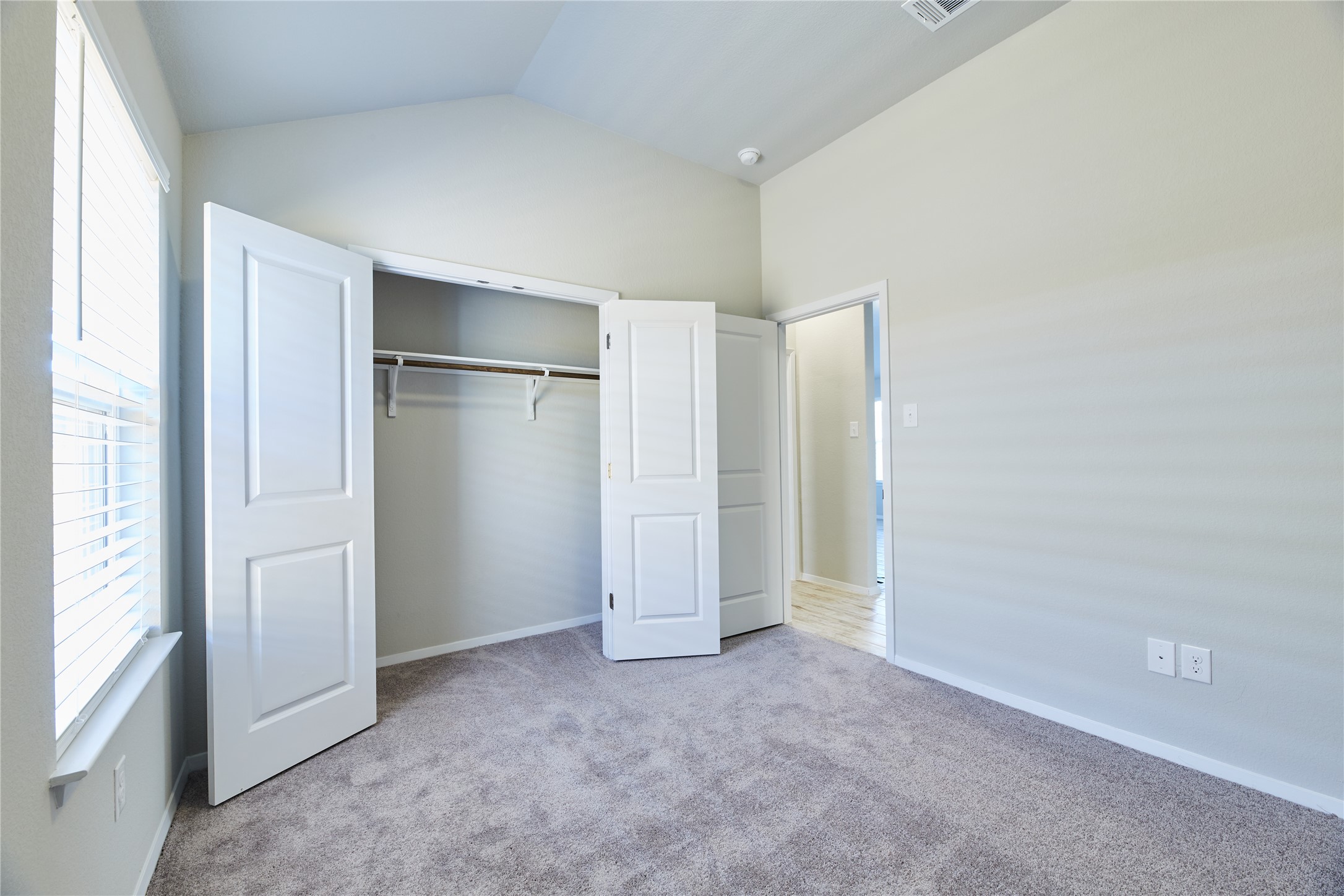 303 Trailside Lane Bastrop, TX 78602 - Photo 19 of 25 Unfurnished bedroom with light colored carpet, lofted ceiling, and a closet