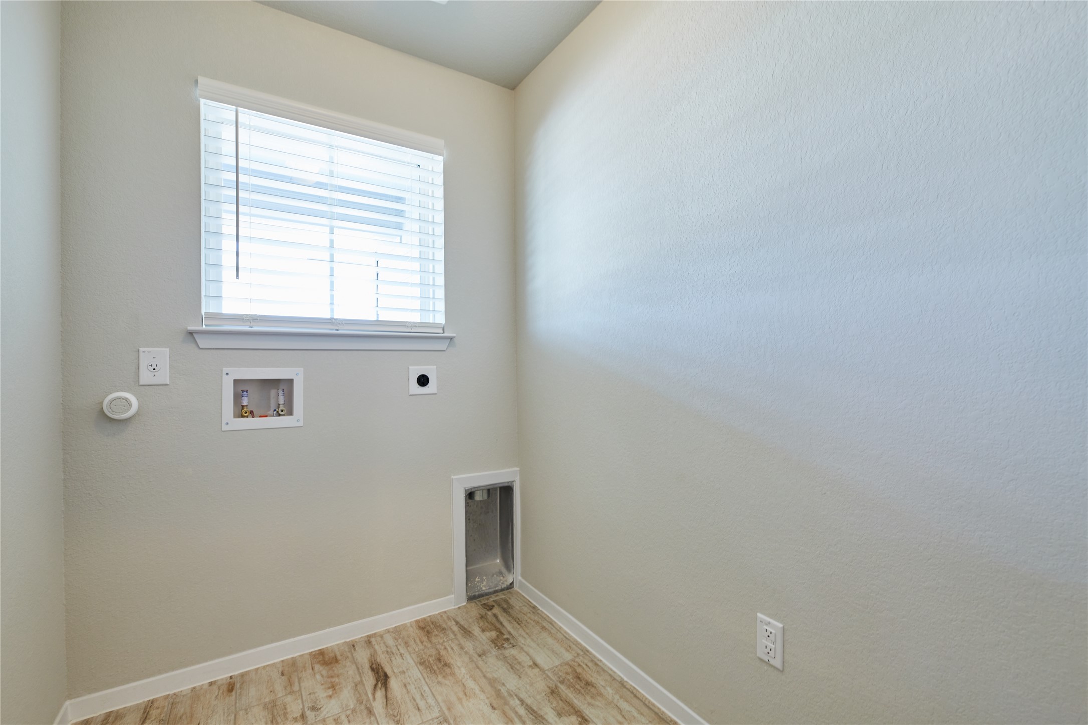 303 Trailside Lane Bastrop, TX 78602 - Photo 20 of 25 Laundry area with electric dryer hookup, washer hookup, and light wood finished floors