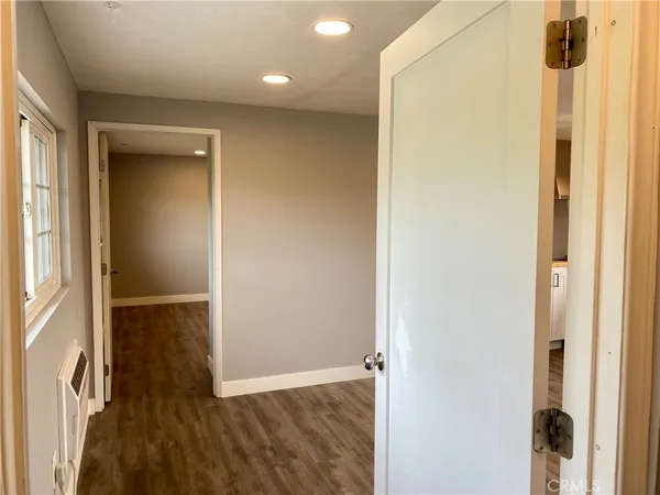 a large white kitchen with granite countertop a stove top oven a sink and dishwasher with wooden floor