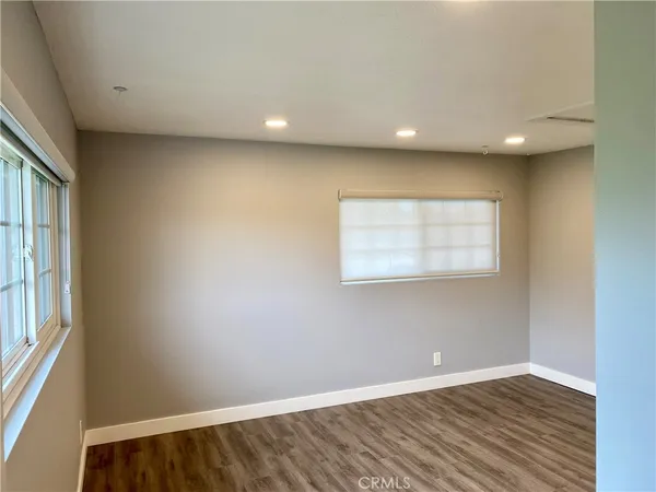 an empty room with wooden floor and door