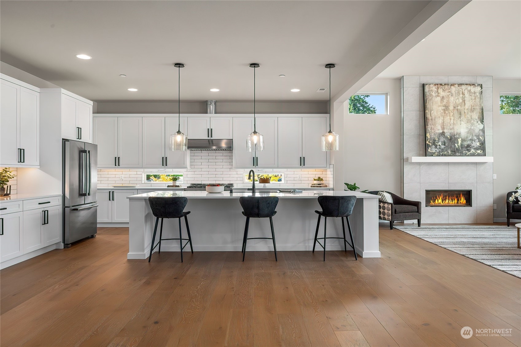23617 23rd Avenue Southeast Bothell, WA 98021 - Photo 12 of 40 a open kitchen with stainless steel appliances kitchen island granite countertop a table chairs and a refrigerator