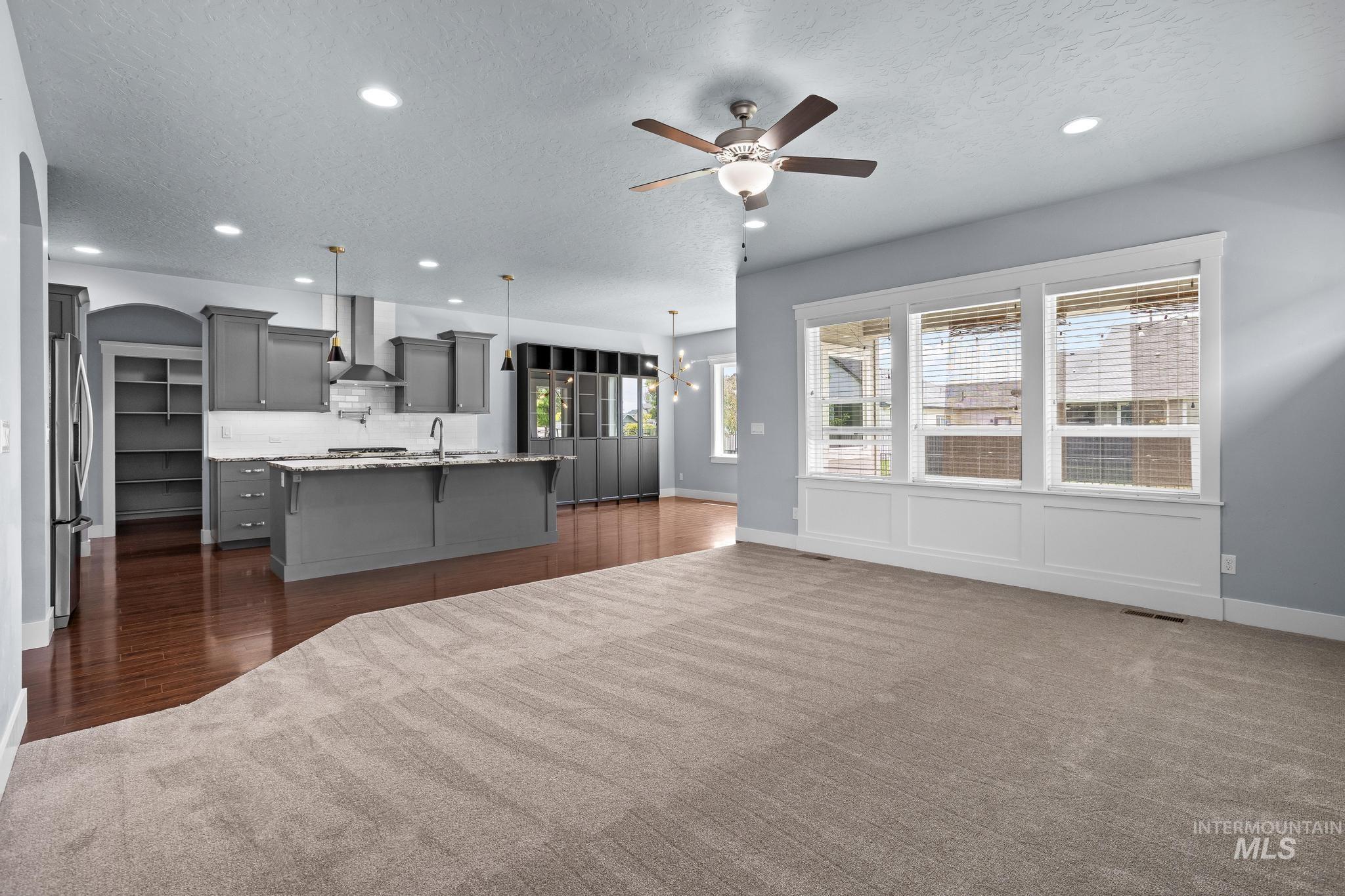 2681 East Rhyolite Court Nampa, ID 83686 - Photo 20 of 48 Open-concept living space featuring a carpeted area and a kitchen with wood-finish flooring