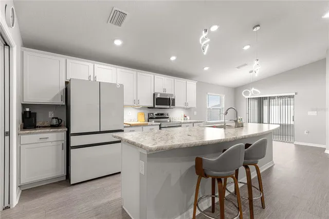a kitchen with refrigerator a sink and cabinets