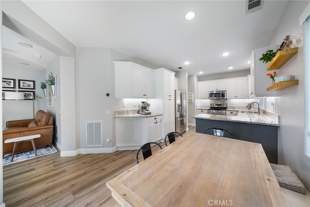 9 Flowerdale Ladera Ranch, CA 92694 - Photo 12 of 54 a kitchen with stainless steel appliances kitchen island granite countertop a sink refrigerator and cabinets