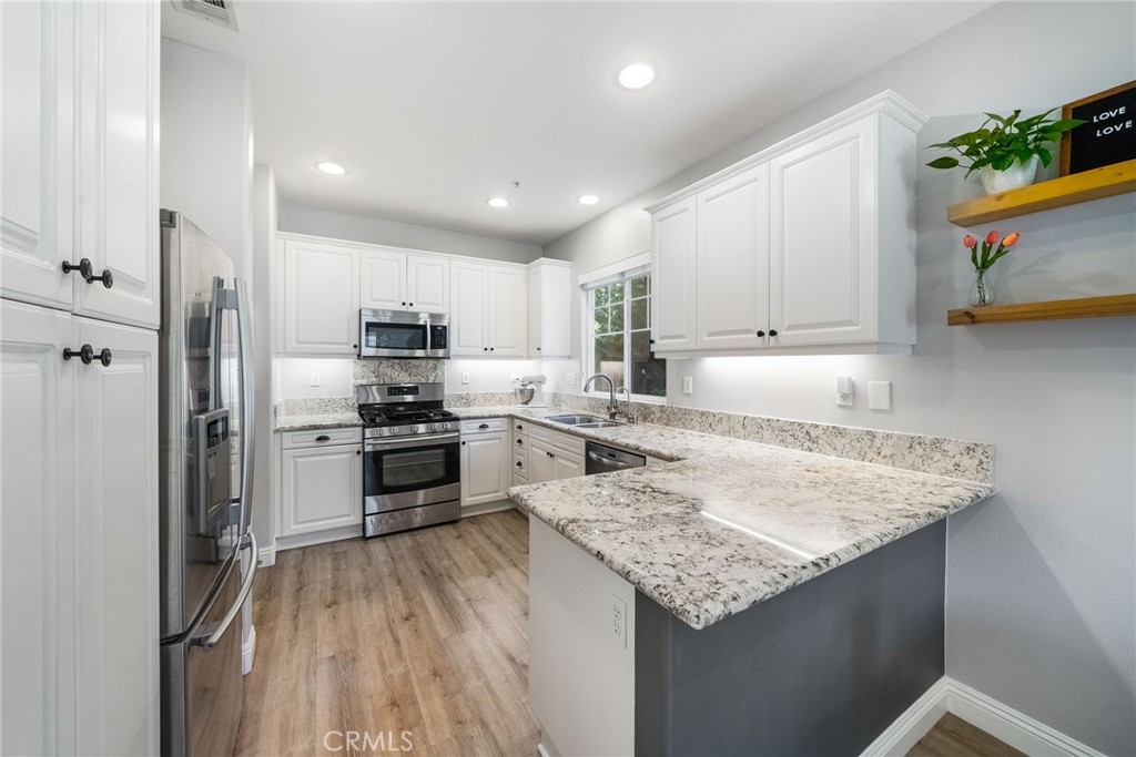 9 Flowerdale Ladera Ranch, CA 92694 - Photo 13 of 54 a kitchen with a refrigerator a stove top oven a sink and cabinets