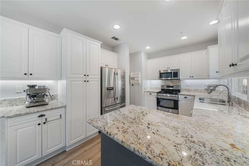 9 Flowerdale Ladera Ranch, CA 92694 - Photo 15 of 54 a kitchen with stainless steel appliances granite countertop a sink refrigerator and cabinets