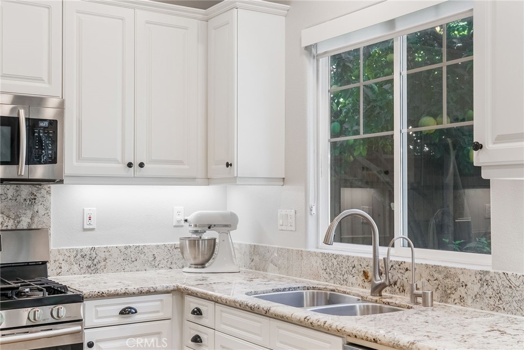 9 Flowerdale Ladera Ranch, CA 92694 - Photo 20 of 54 a kitchen with granite countertop a sink stove and cabinets