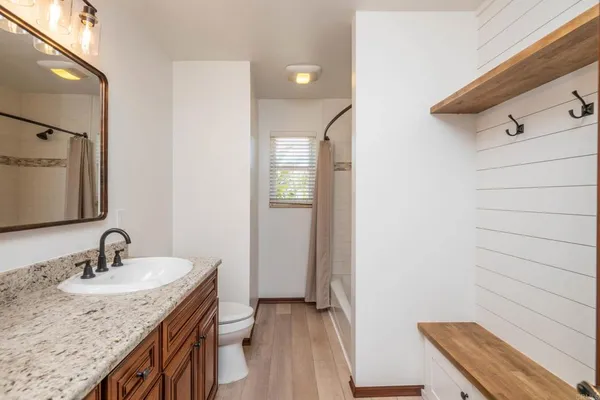 a bathroom with a granite countertop sink and a mirror