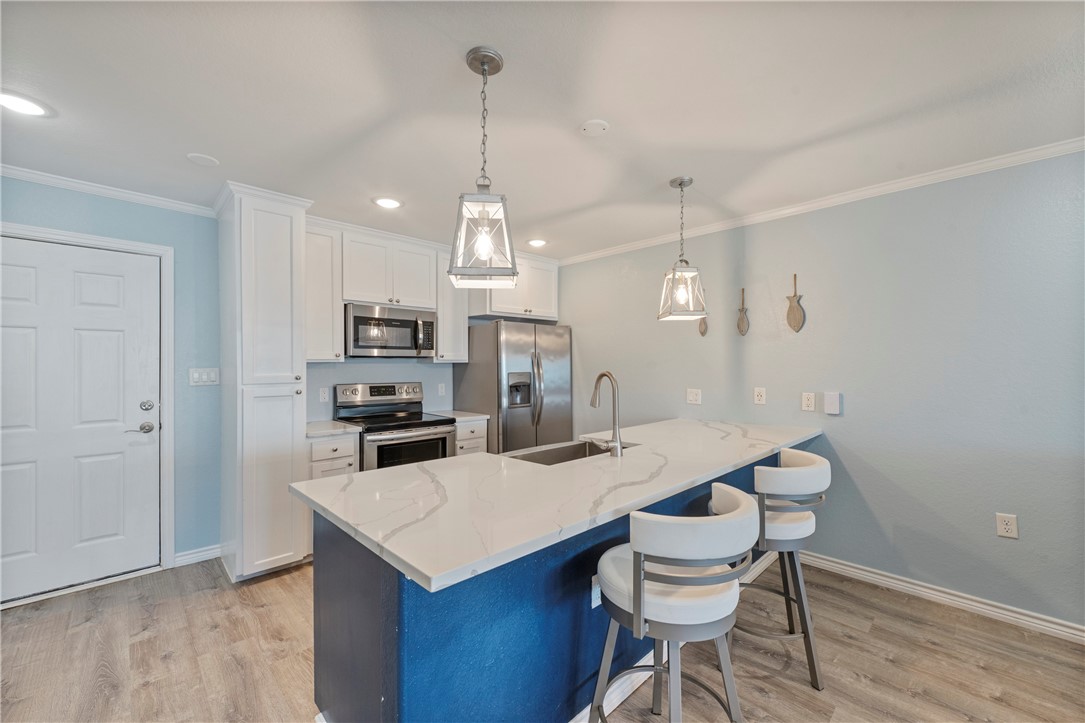 800 Beach Access Road Port Aransas, TX 78373 - Photo 2 of 13 a kitchen that has a table chairs and wooden floor