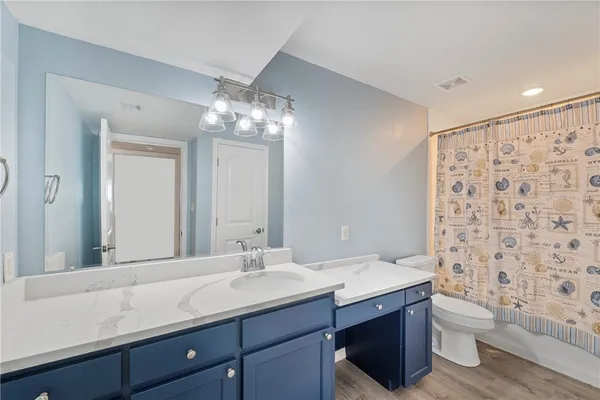 a bathroom with a double vanity sink toilet and a mirror