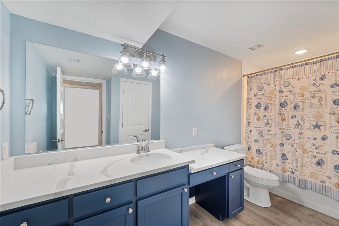 800 Beach Access Road Port Aransas, TX 78373 - Photo 6 of 13 a bathroom with a double vanity sink toilet and a mirror