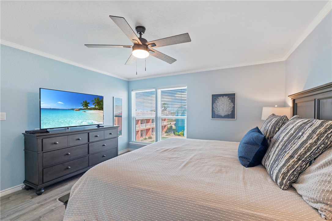 800 Beach Access Road Port Aransas, TX 78373 - Photo 8 of 13 a bedroom with a bed and a flat screen tv