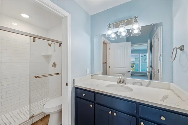 a bathroom with a sink shower and a mirror
