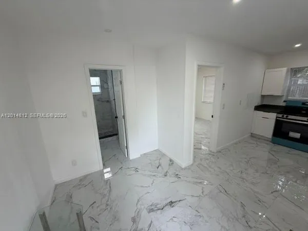 a kitchen with granite countertop white cabinets and black appliances