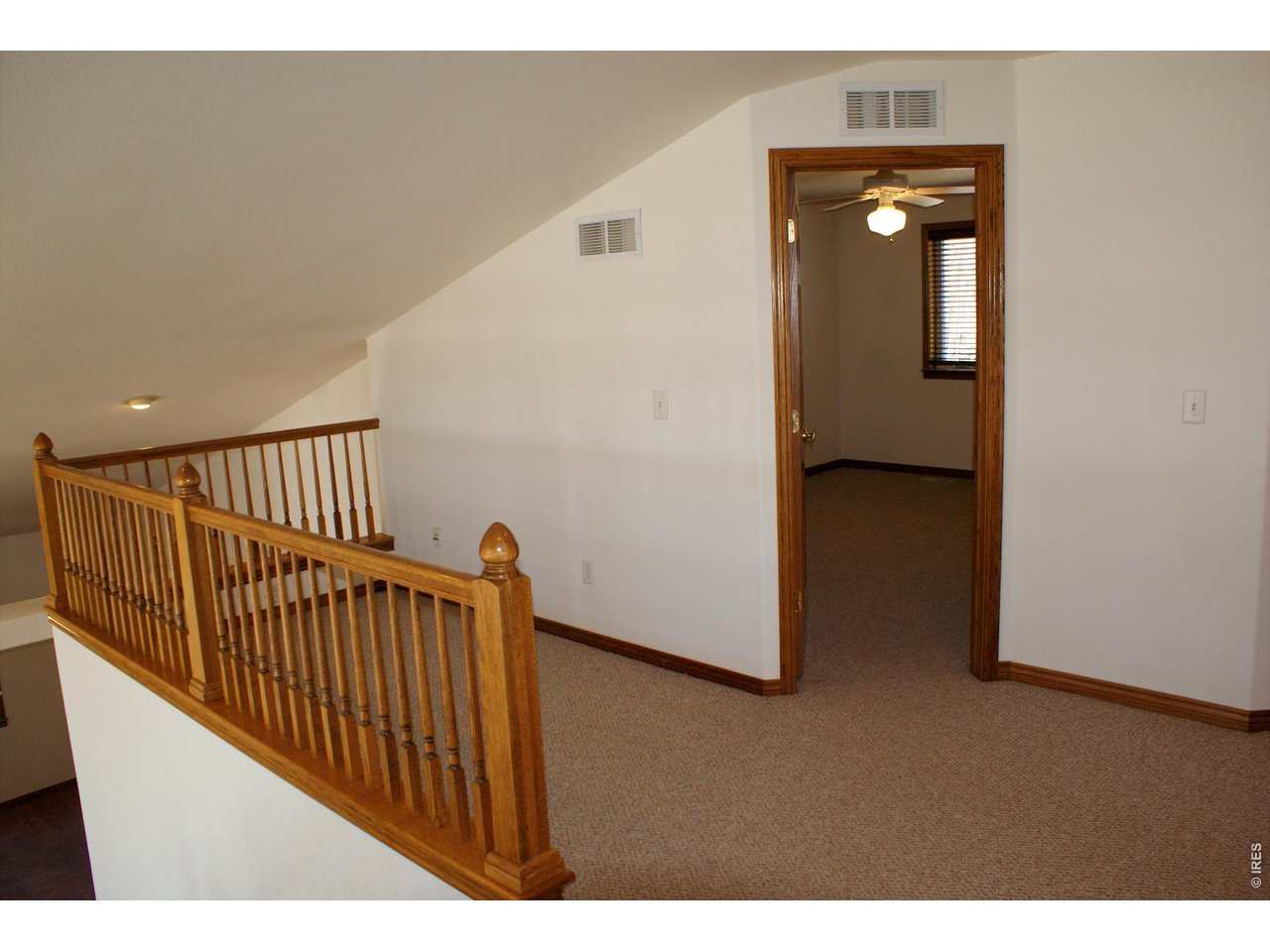 6576 Saddleback Avenue Firestone, CO 80504 - Photo 16 of 25 a view of a hallway to a room with wooden floor and windows