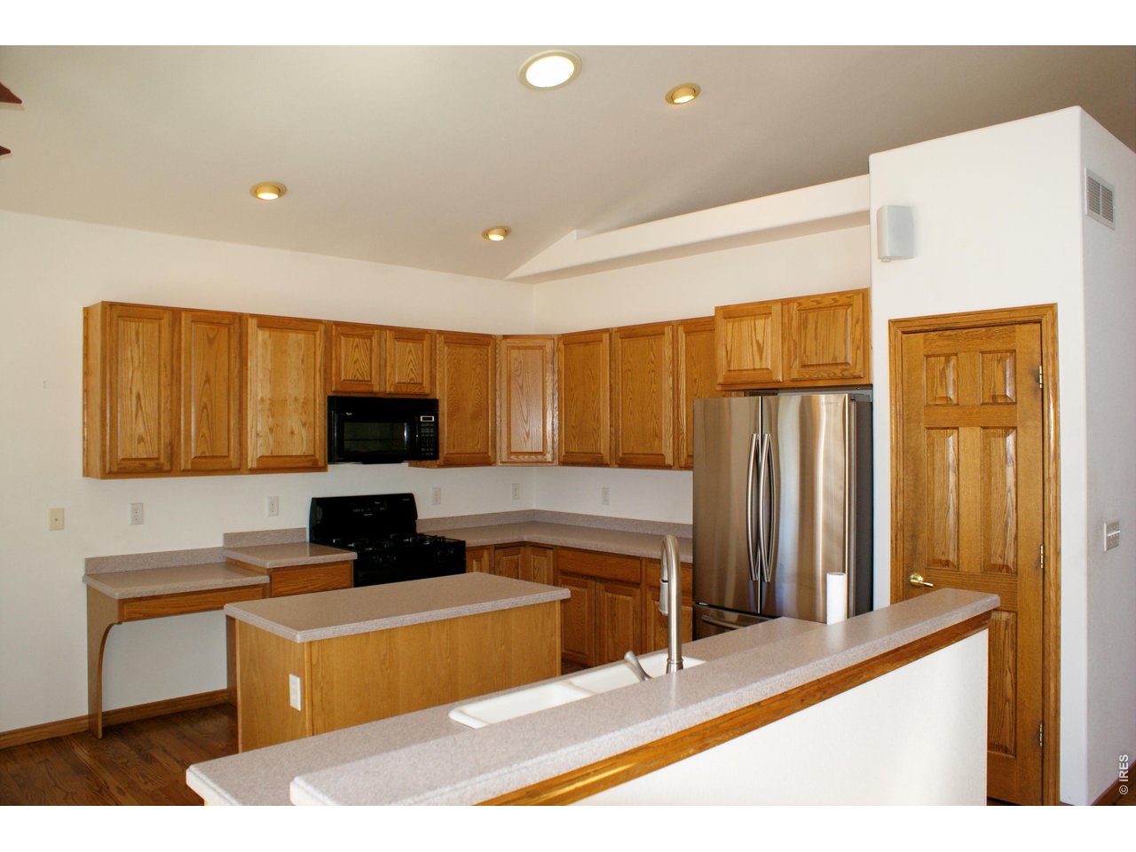 6576 Saddleback Avenue Firestone, CO 80504 - Photo 8 of 25 a living room with stainless steel appliances kitchen island a sink a stove and a refrigerator