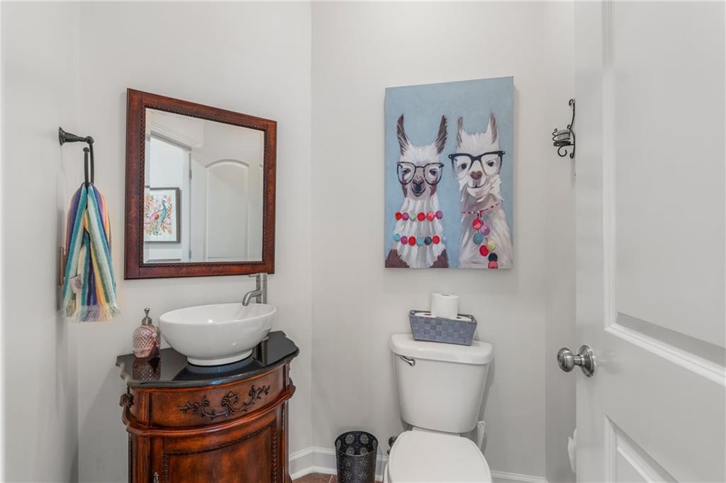 642 Nuckols Road Seale, AL 36875 - Photo 29 of 48 White vessel sink with a dark wood-finish vanity, framed mirror, and a sleek wall-mounted towel bar