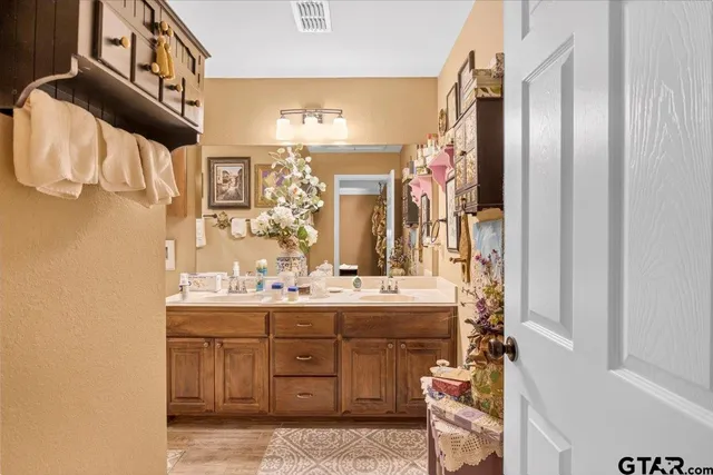 a bathroom with a double vanity sink a mirror and a bathtub