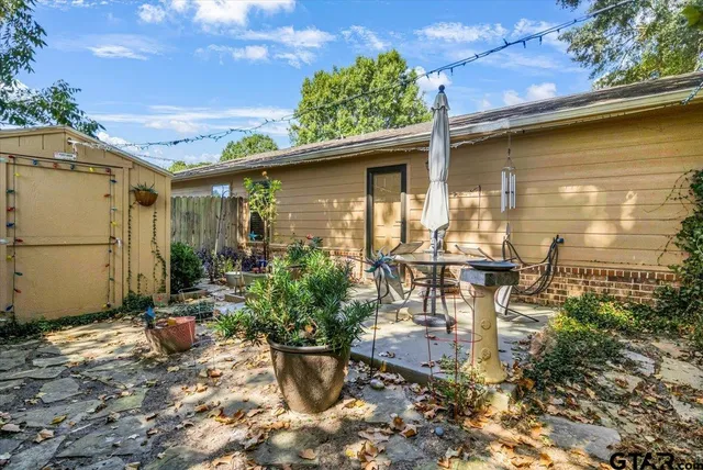 a backyard of a house with table and chairs