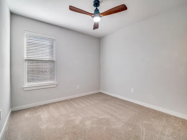 a view of a livingroom with a ceiling fan and window