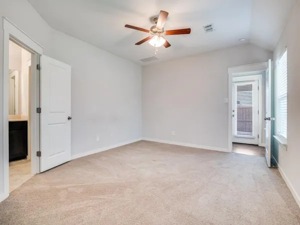 an empty room with closet and a ceiling fan