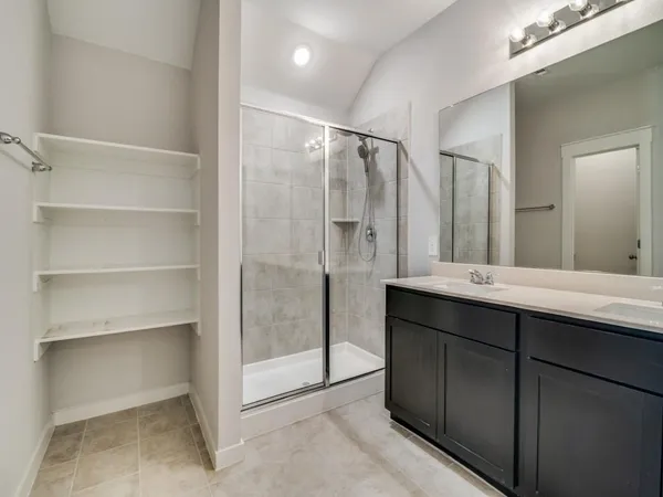 a bathroom with a double vanity sink mirror and shower