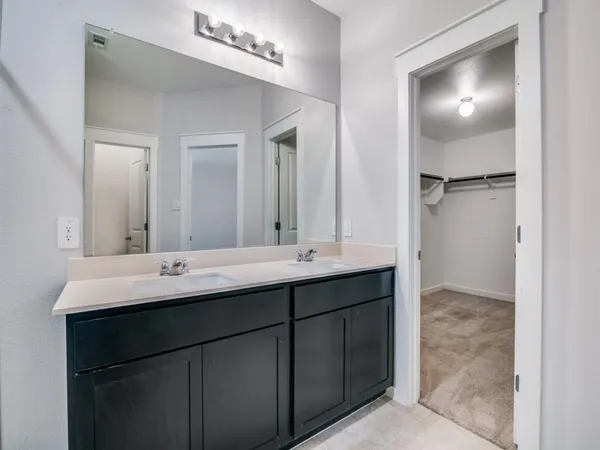 a bathroom with a double vanity sink and a mirror