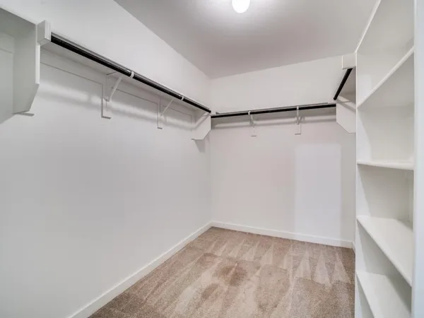 a view of walk in closet with empty racks
