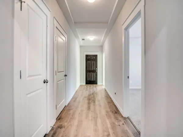 a view of a hallway with wooden floor