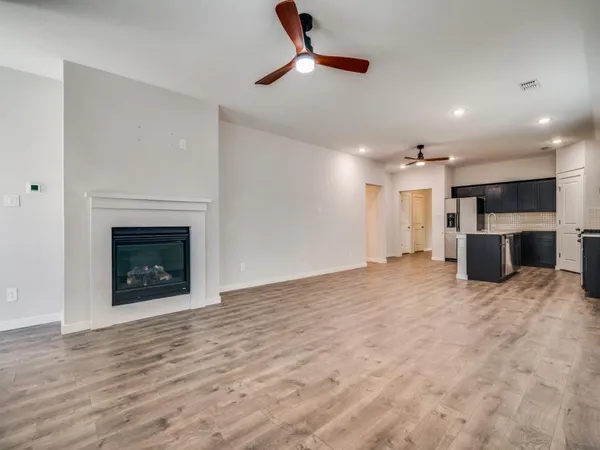 a view of an empty room with a fireplace and a window