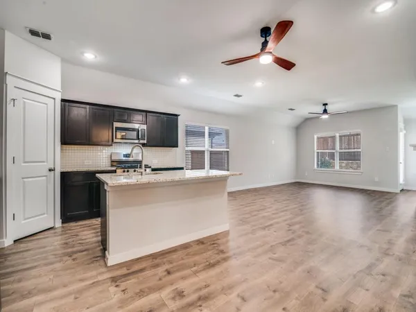 a view of kitchen with sink microwave and refrigerator