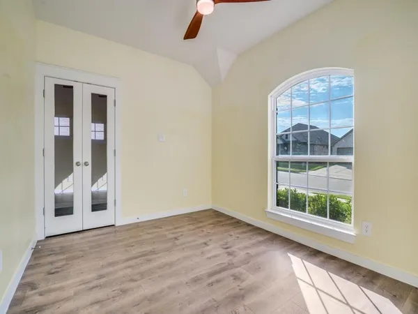 an empty room with wooden floor and windows