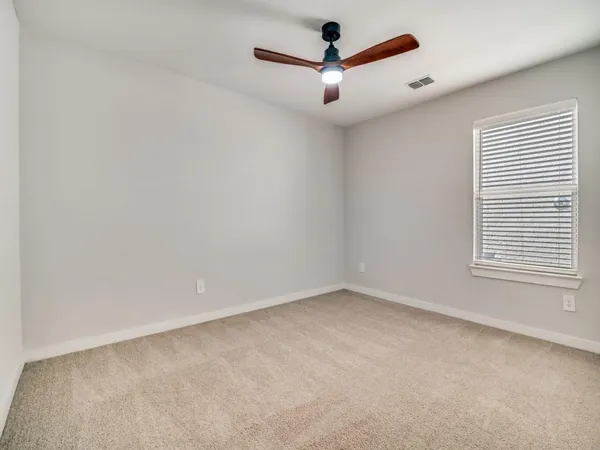 an empty room with a window and a fan