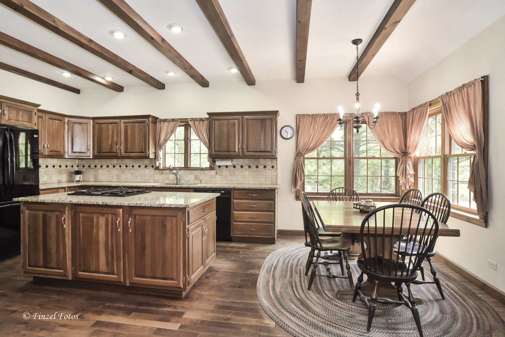 3816 Deep Cut Road Woodstock, IL 60098 - Photo 10 of 32 a kitchen with stainless steel appliances granite countertop a stove top oven a sink dishwasher a dining table and chairs with wooden floor