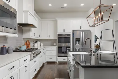 a kitchen with stainless steel appliances granite countertop a sink stove and cabinets