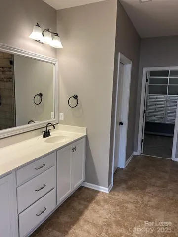 a spacious bathroom with a double vanity sink a mirror and a shower