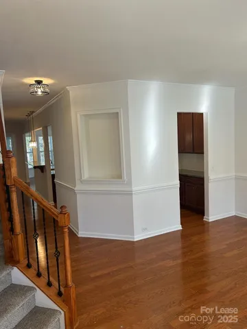 a view of a livingroom with wooden floor and stairs