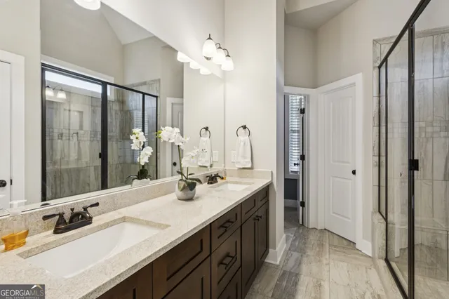 a spacious bathroom with a double vanity sink mirror and shower