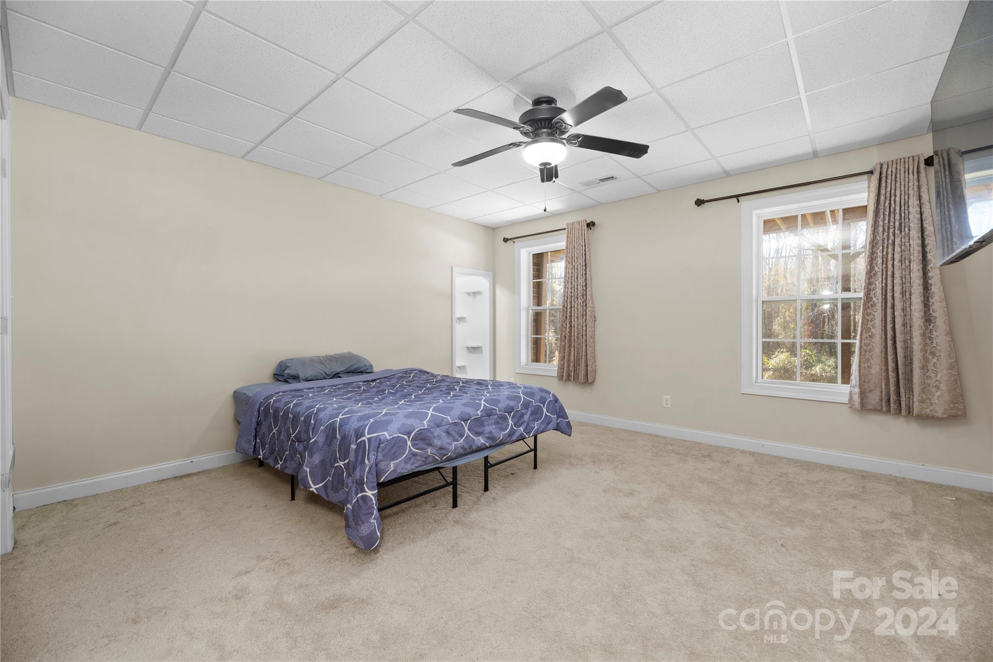 1350 Kensington Circle Newton, NC 28658 - Photo 30 of 45 a spacious bedroom with a bed chandelier and a window